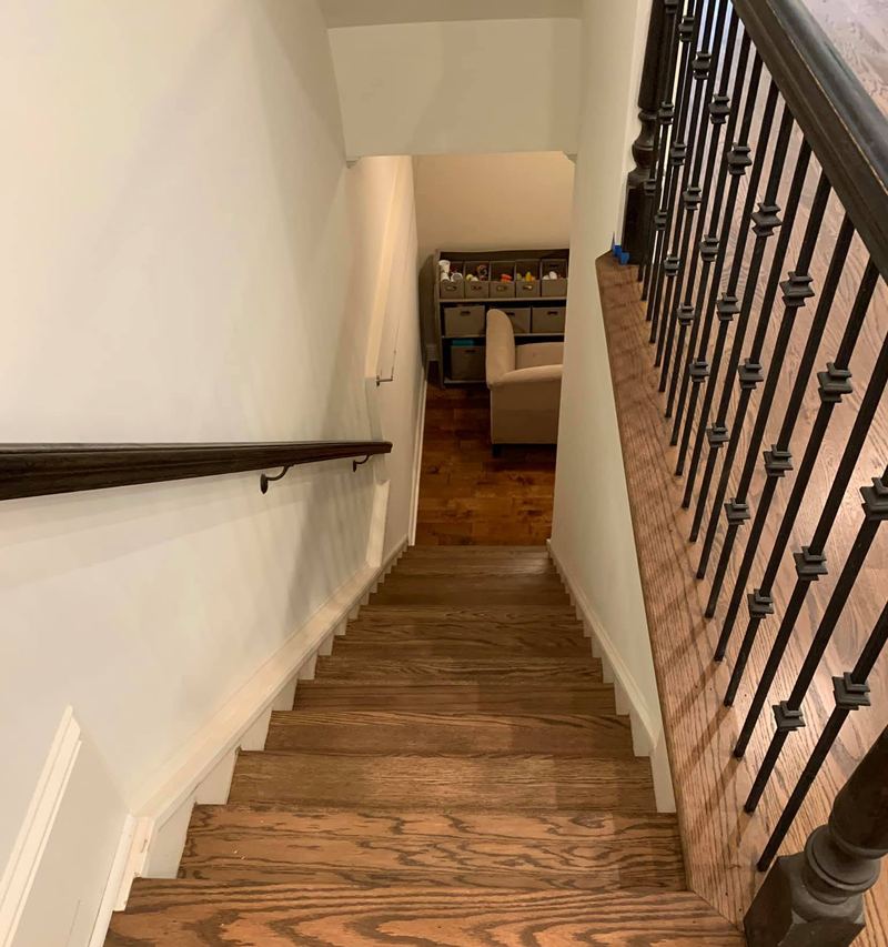 Narrow staircase with oak treads finished to match the floor and iron balusters