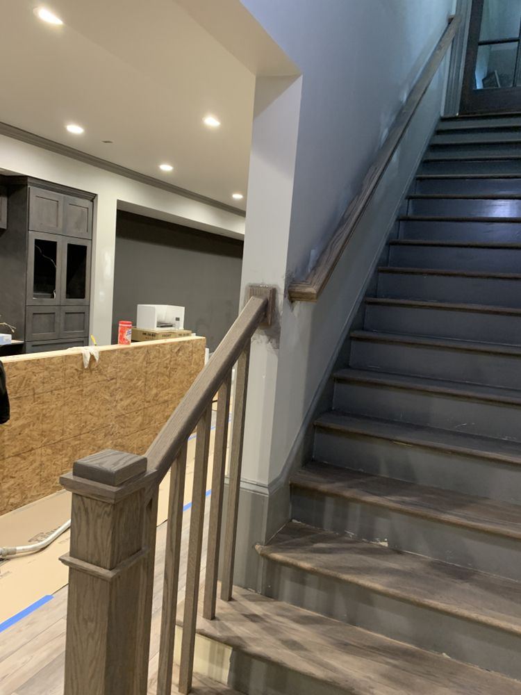 Basement staircase with gray stained treads and handrail