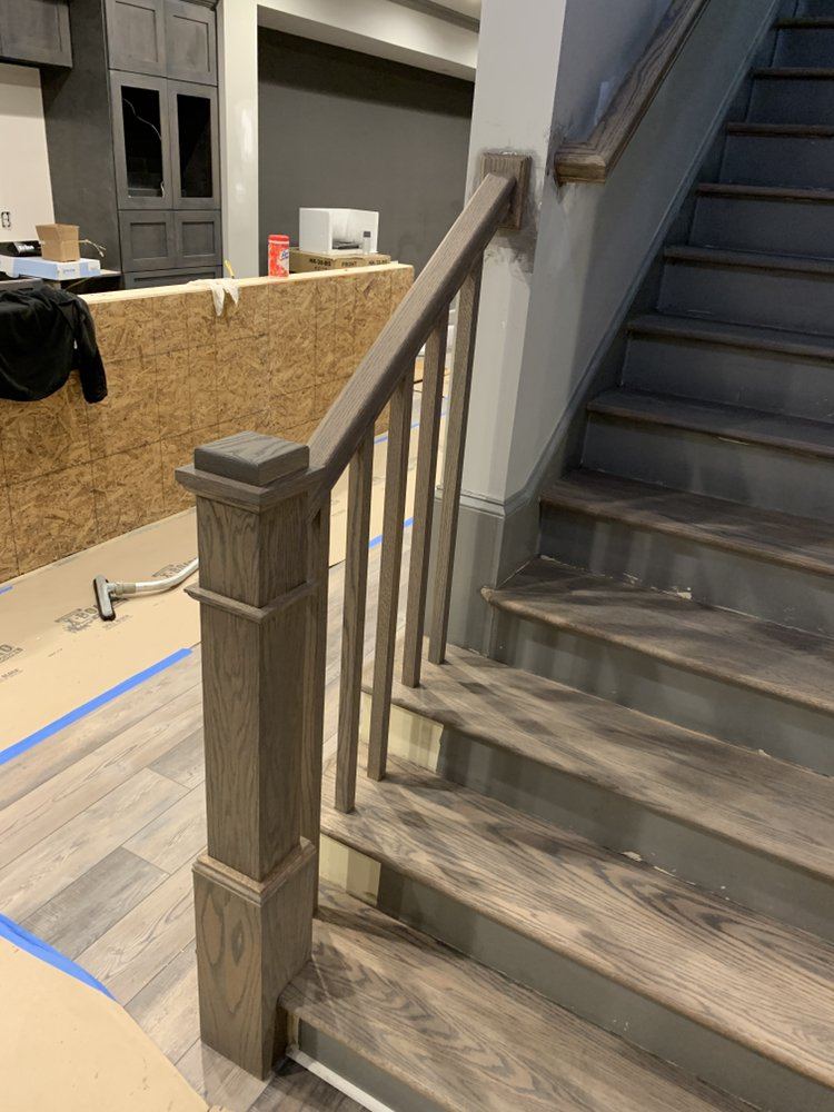 Basement stairs with gray stained oak treads, newel post and wood balusters