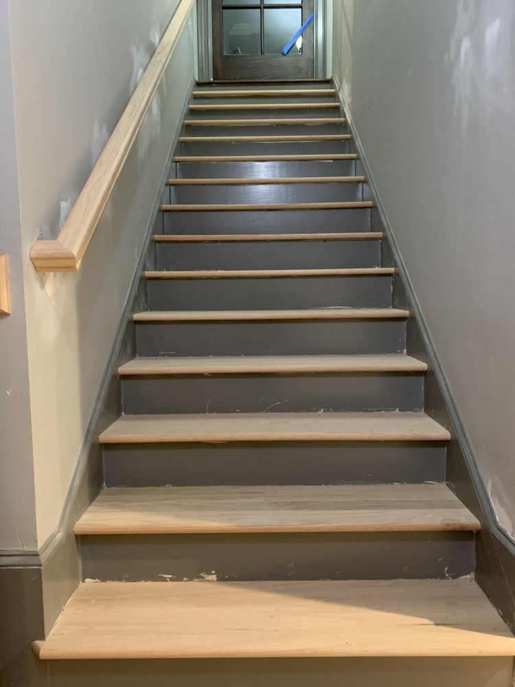 Staircase with new raw oak treads over gray painted risers