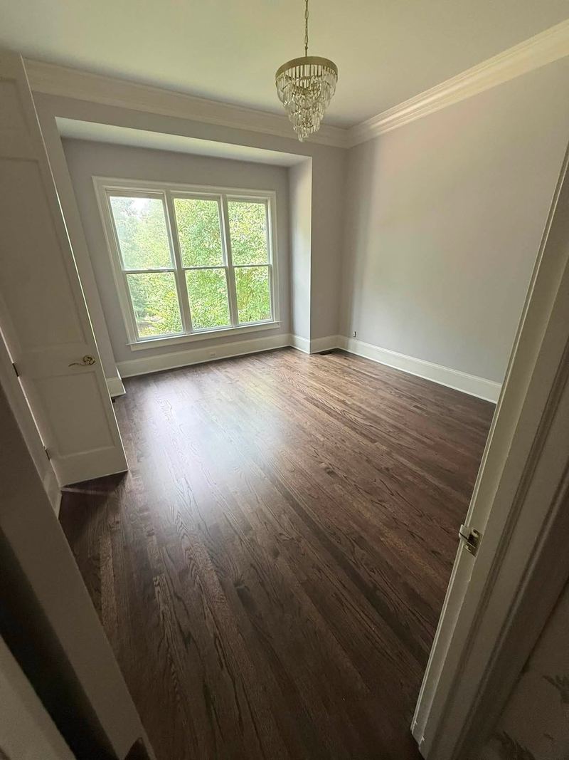 Bedroom with a crystal light fixture and a dark stained oak floor