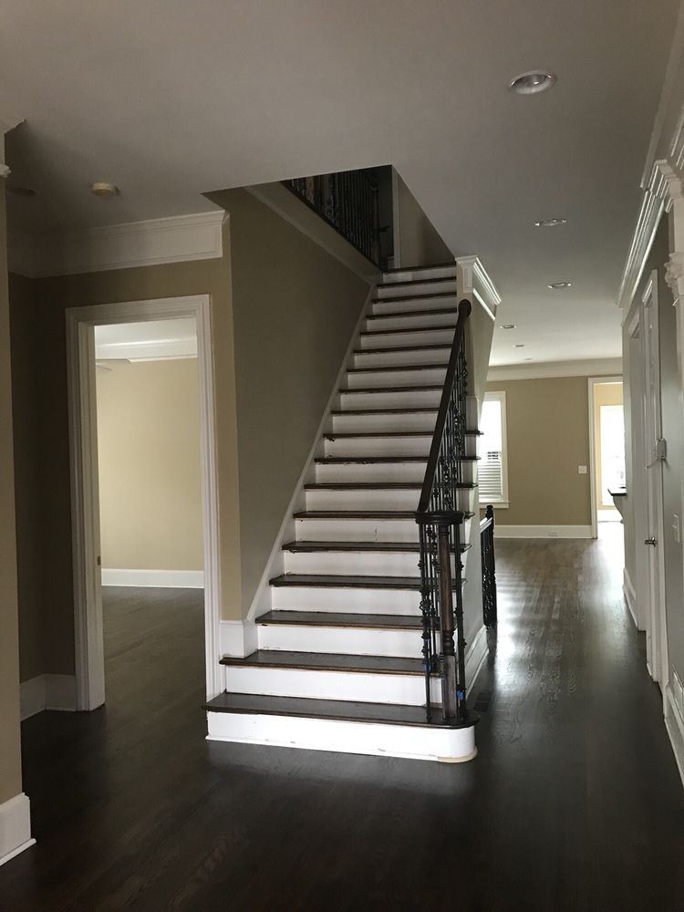 Foyer staircase with dark treads and white risers above a dark oak floor