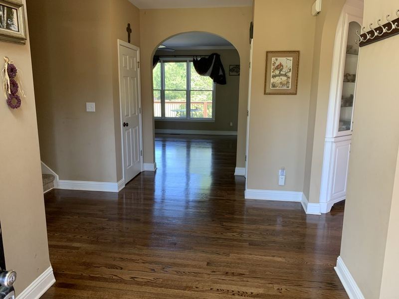 Front hall with an arched opening and a brown stained oak floor