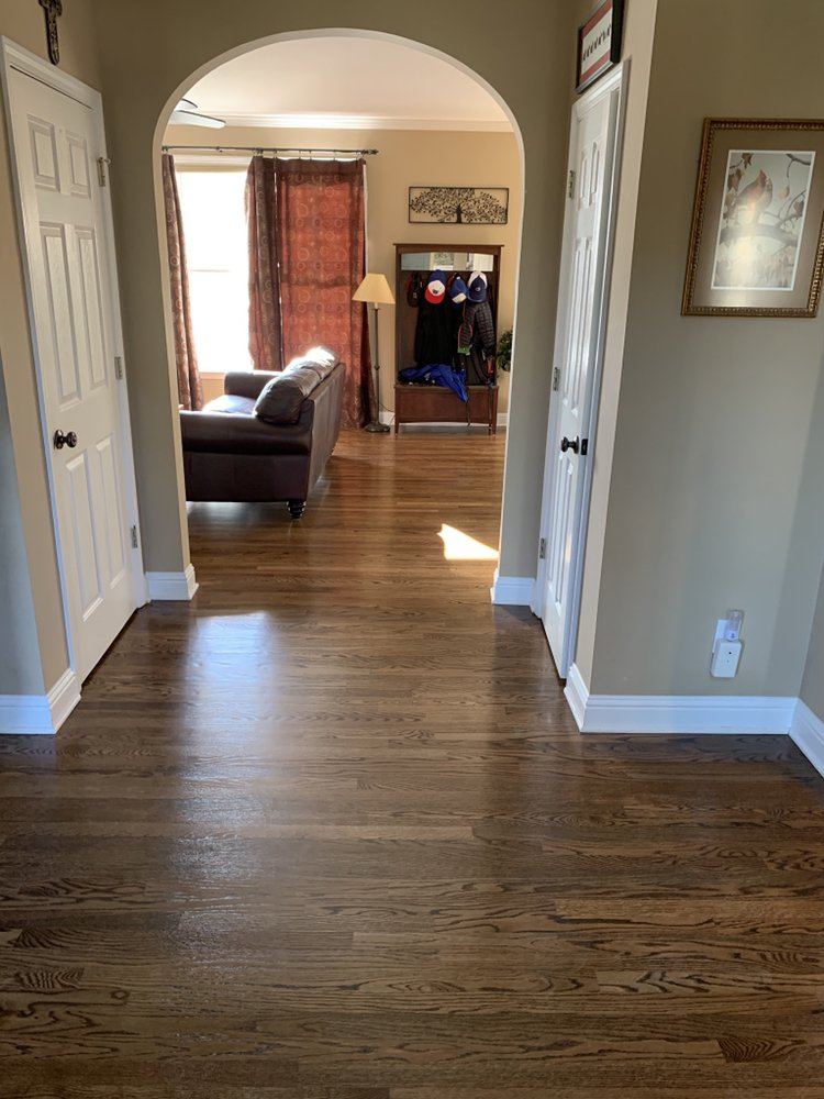 Hallway leading to a living room over a brown stained oak floor
