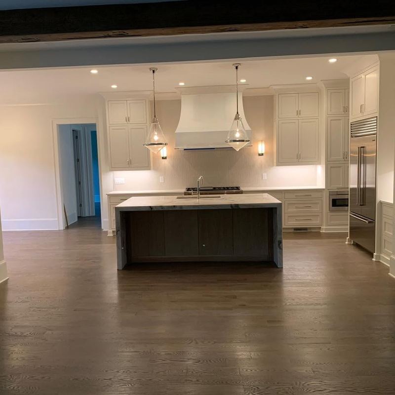 Modern kitchen with a dark island over a gray-brown stained oak floor