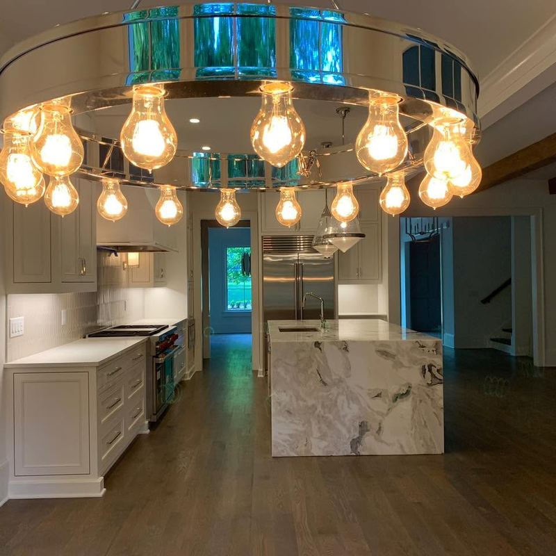 Kitchen with a marble waterfall island over a gray-brown oak floor