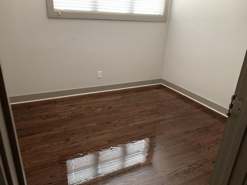 Small room with a glossy dark stained oak floor right after the final coat