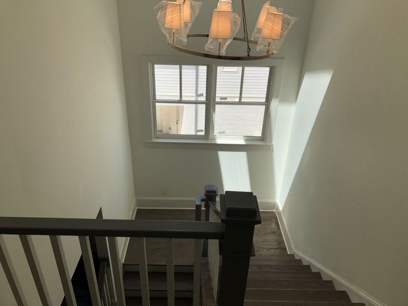 View down a staircase with dark treads from the upstairs landing