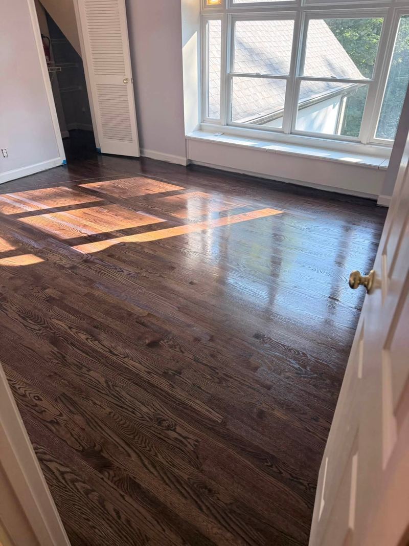Sunlight across a freshly finished dark stained oak floor below a window seat